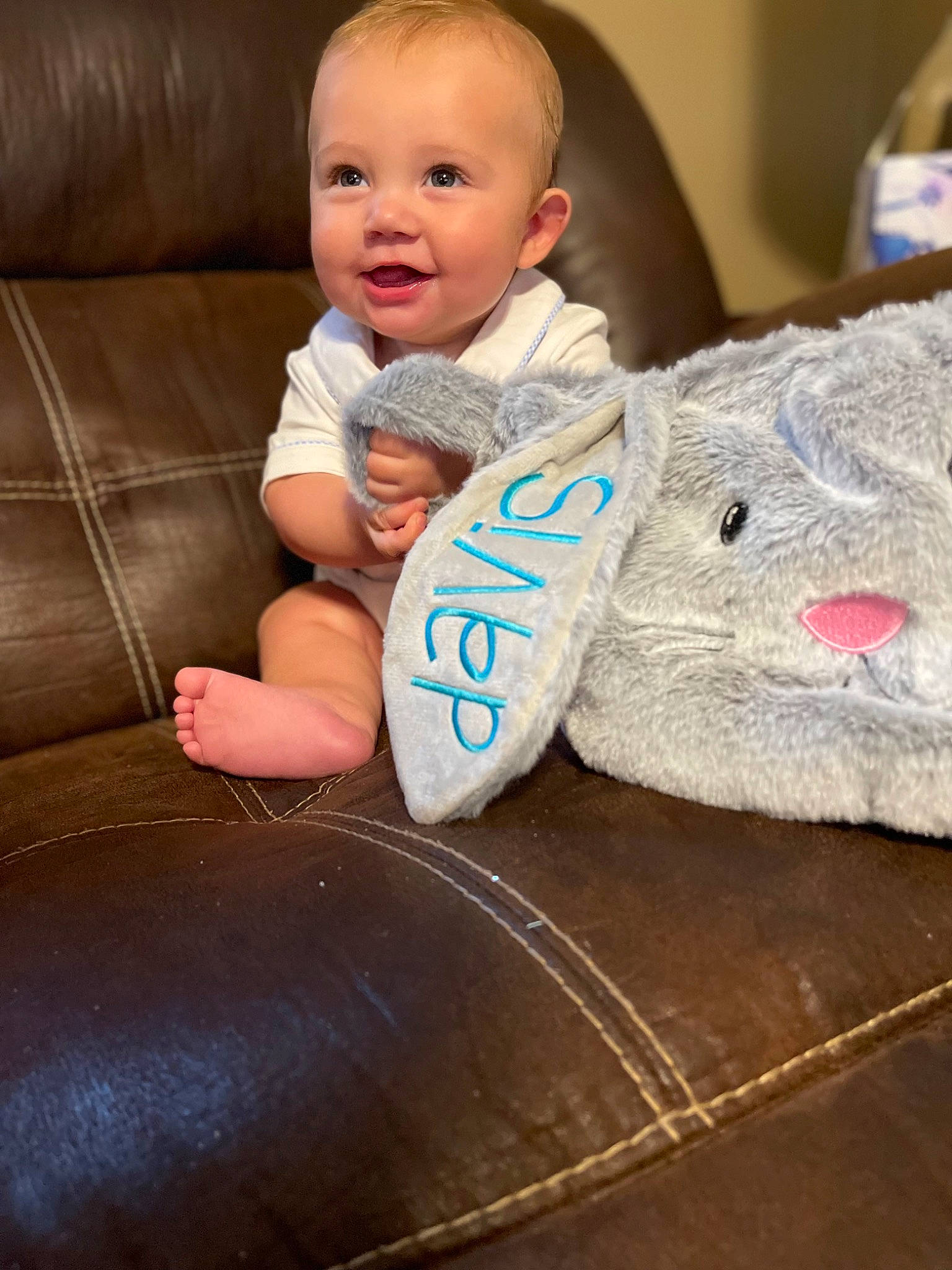 Davis joined the competition — help win amazing prizes! baby, baby_toddler_clothing, child, comfort, couch, face, facial_expression, finger, floor, flooring, happy, human_leg, linens, person, sitting, skin, sleeve, smile, t_shirt, toddler
