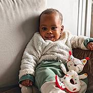 Muhammad a rejoint le concours — aidez-le/la à gagner de superbes lots ! baby, child, smiling, couch, plush_toy, soft_jacket, pants, indoor, cozy, relaxed, portrait, cute, infant, furniture, home, person, toy, comfort, warm, happy