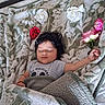 baby, bed, blanket, bouquet, child, cozy, dark_hair, face, floral, flower, gray_shirt, home, indoors, infant, lying_down, nap, peaceful, portrait, roses, sleeping