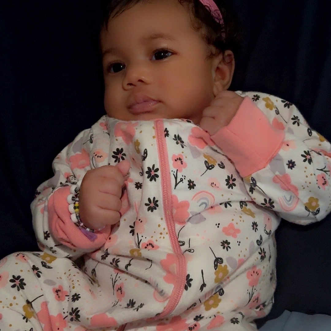 Avaylah is registered to the contest to win money with this photo: accessories, baby, bodypart, bonnet, clothing, couch, cushion, dress, face, finger, furniture, hand, hat, head, homedecor, newborn, pajamas, person, photography, portrait