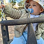 Sohan participe au concours pour gagner de l'argent avec cette photo : child, toddler, baby, pacifier, bucket_hat, jacket, coat, swing, swing_chain, playground, outdoors, hand, jeans, seat, gravel, portrait, closeup, daytime, person, hat