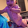Skylar joined the competition — help win amazing prizes! baby, bed, bedroom, blanket, child, crawling, face, happy, home, indoor, infant, laughing, person, pink_clothing, portrait, sitting, smiling, stuffed_toy, toy, warm_lighting