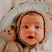 Rohan joined the competition — help win amazing prizes! baby, infant, knitted_hat, bear_ears, crocheted_teddy_bear, blanket, cozy, cute, wide_eyes, surprised_expression, soft_texture, portrait, child, newborn, indoors, warm, snuggled, sleeping_area, adorable, headwear