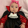 baby, child, costume, vampire, cape, fangs, pink_headband, bow, dress, red, black, halloween, decoration, bat, orange, face, portrait, cute, infant, holiday