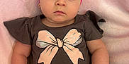 Kylie is registered to the contest to win money with this photo: baby, child, pink_bow, headband, brown_shirt, pink_shorts, bracelet, soft_blanket, cute, infant, portrait, indoor, clothing, sitting, expression, adorable, person, baby_fashion, closeup, toddler