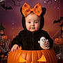 baby, child, halloween, jack_o_lantern, pumpkin, costume, ghost_plush, black_clothing, orange_bow, spiderweb_pattern, skeleton_toy, decorations, cobweb, bats, fall_leaves, cute, portrait, holiday, festive, indoor