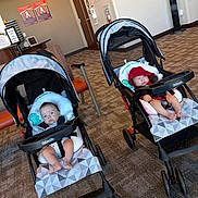 Alejandro Guerrero is registered to the contest to win money with this photo: baby, baby_clothing, carpet, child, door, expression, floor, footwear, furniture, headwear, indoor, infant, person, pillow, red_hat, seat, stroller, toy, waiting_room, wall_art