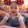 Alora Grace joined the competition — help win amazing prizes! baby, child, smiling, mickey_ears, headband, stroller, outdoor, balloons, castle, sunset, happy, cute, denim_overalls, tshirt, portrait, flower_bed, people, background_blur, daytime, playful