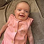 baby, infant, smiling, pink_outfit, bunny_design, blanket, couch, happy, face, head, arm, buttoned_clothing, soft_texture, indoor, cute, person, portrait, lying_down, child, cozy