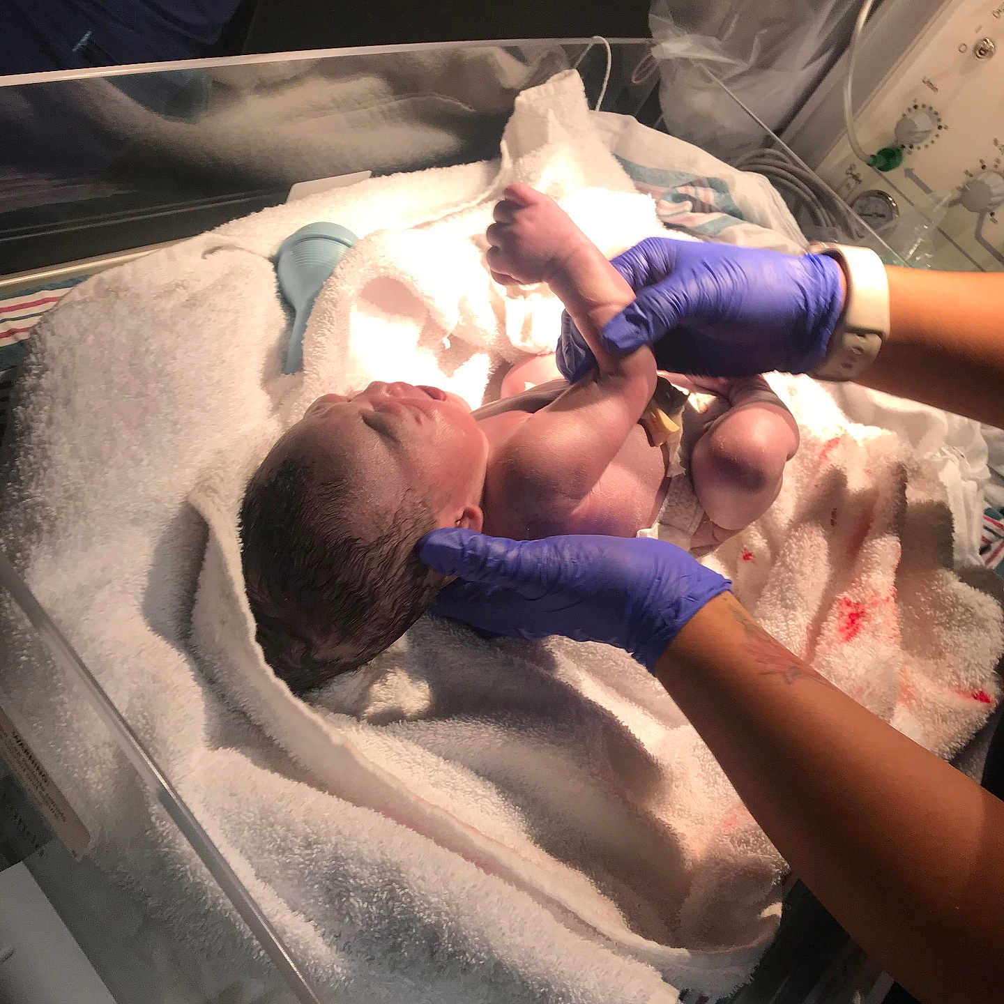 Lj is registered to the contest to win money with this photo: newborn, baby, hospital, medical_gloves, towel, infant, person, hands, blanket, bed, newborn_care, healthcare, clinic, medical_equipment, skin, fresh, delivery, birth, human, patient