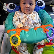 Malakai joined the competition — help win amazing prizes! baby, infant, child, onesie, tiger_pattern, baby_seat, toy, colorful, playful, tongue_out, cute, indoor, comfort, seat, happy, face, person, clothing, baby_toys, expression