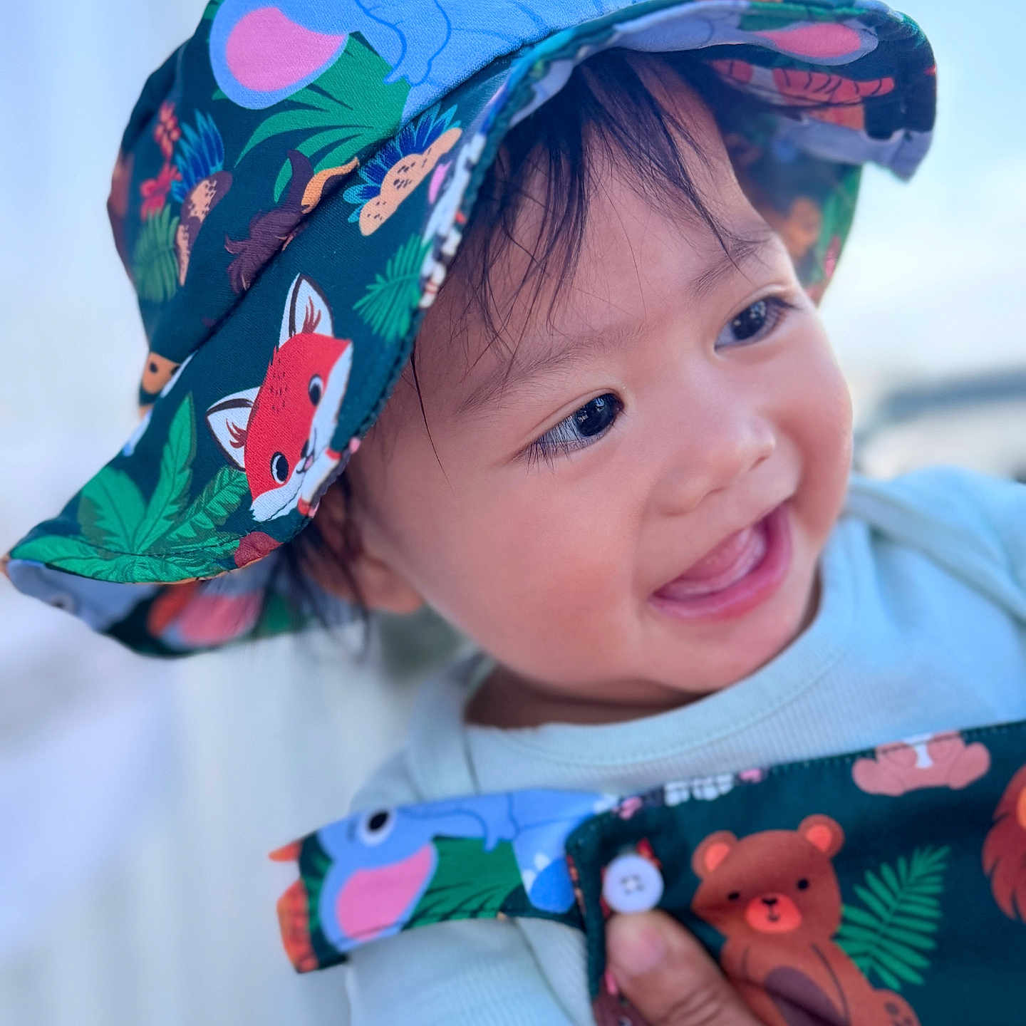 Ryler Isidore is registered to the contest to win money with this photo: baby, child, infant, smiling, happy, portrait, face, eyes, mouth, hat, bucket_hat, animal_print, colorful, clothing, sleeve, hand, indoors, close_up, photography, joyful