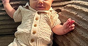 Brooks joined the competition — help win amazing prizes! baby, infant, child, smiling, portrait, sitting, indoor, blanket, couch, knitted_clothing, cream_outfit, sweater, buttons, plush, cozy, waving, outstretched_hand, happy, face, photography