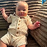 baby, infant, child, smiling, portrait, sitting, indoor, blanket, couch, knitted_clothing, cream_outfit, sweater, buttons, plush, cozy, waving, outstretched_hand, happy, face, photography