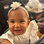 toddler, smiling, child, headband, flower, white_clothing, stroller, baby, happy, cute, portrait, face, eyes, skin, infant, young_child, indoor, person, closeup, seat