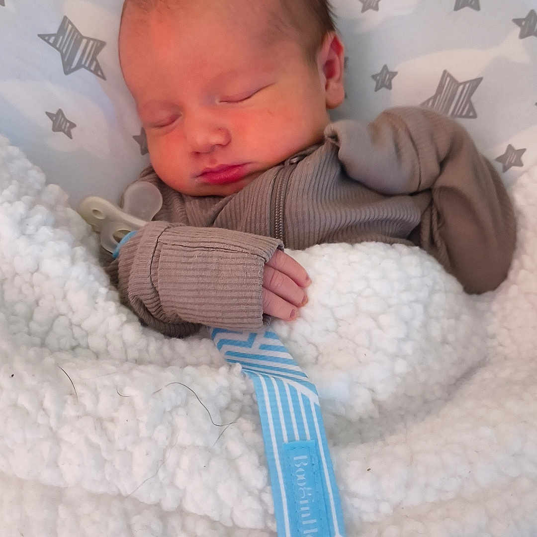 Wallen is registered to the contest to win money with this photo: baby, blanket, bundle, child, clothing, cozy, cute, fabric, face, hand, indoors, infant, newborn, pacifier, peaceful, pillow, resting, sleeping, soft, star_pattern