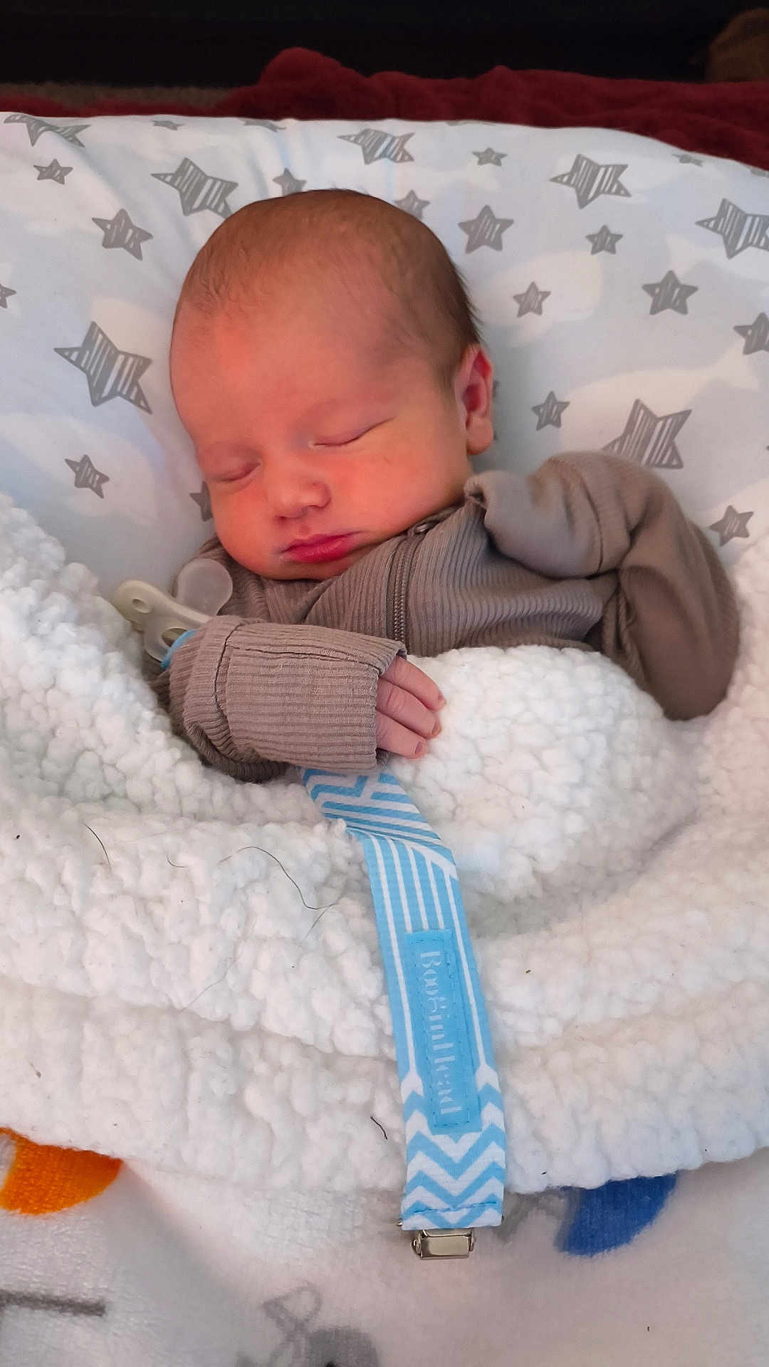 Wallen is registered to the contest to win money with this photo: newborn, baby, sleeping, blanket, pillow, pacifier, clothing, infant, cozy, soft, hand, face, peaceful, indoors, cute, child, resting, star_pattern, fabric, bundle