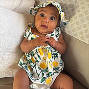 Simea a rejoint le concours — aidez-le/la à gagner de superbes lots ! baby, infant, child, sitting, couch, clothing, hat, floral_pattern, hands, face, eyes, indoors, cushion, comfort, expression, portrait, skin, cute, young, relaxation