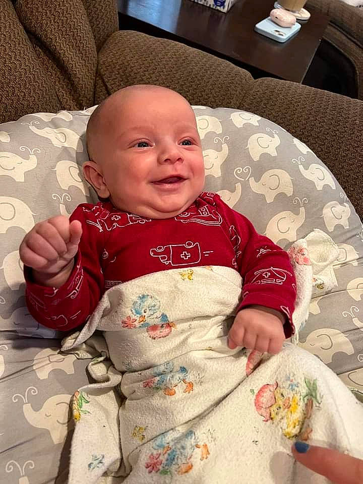 Carsen is registered to the contest to win money with this photo: baby, baby_toddler_clothing, carmine, cheek, child, comfort, couch, flooring, happy, head, linens, pattern, person, product, room, sitting, skin, sleeve, smile, thumb