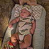 Sion is registered to the contest to win money with this photo: baby, newborn, sleeping, infant, dinosaur_outfit, hat, cushion, blanket, pillow, onesie, portrait, indoor, cozy, sitting, lying_down, closed_eyes, peaceful, textile, furniture, family_photo