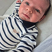 Robin a rejoint le concours — aidez-le/la à gagner de superbes lots ! baby, infant, striped_clothing, whale_emblem, lying_down, curious_eyes, face, hand, cozy, cute, child, person, soft_lighting, indoor, portrait, newborn, clothing, fabric, closeup, expression