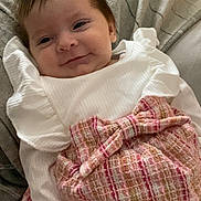 Ayrah joined the competition — help win amazing prizes! baby, infant, smile, white_clothing, pink_skirt, bow, blanket, couch, cozy, child, portrait, cute, happy, person, indoors, soft_lighting, resting, young_child, fashion, ribbons