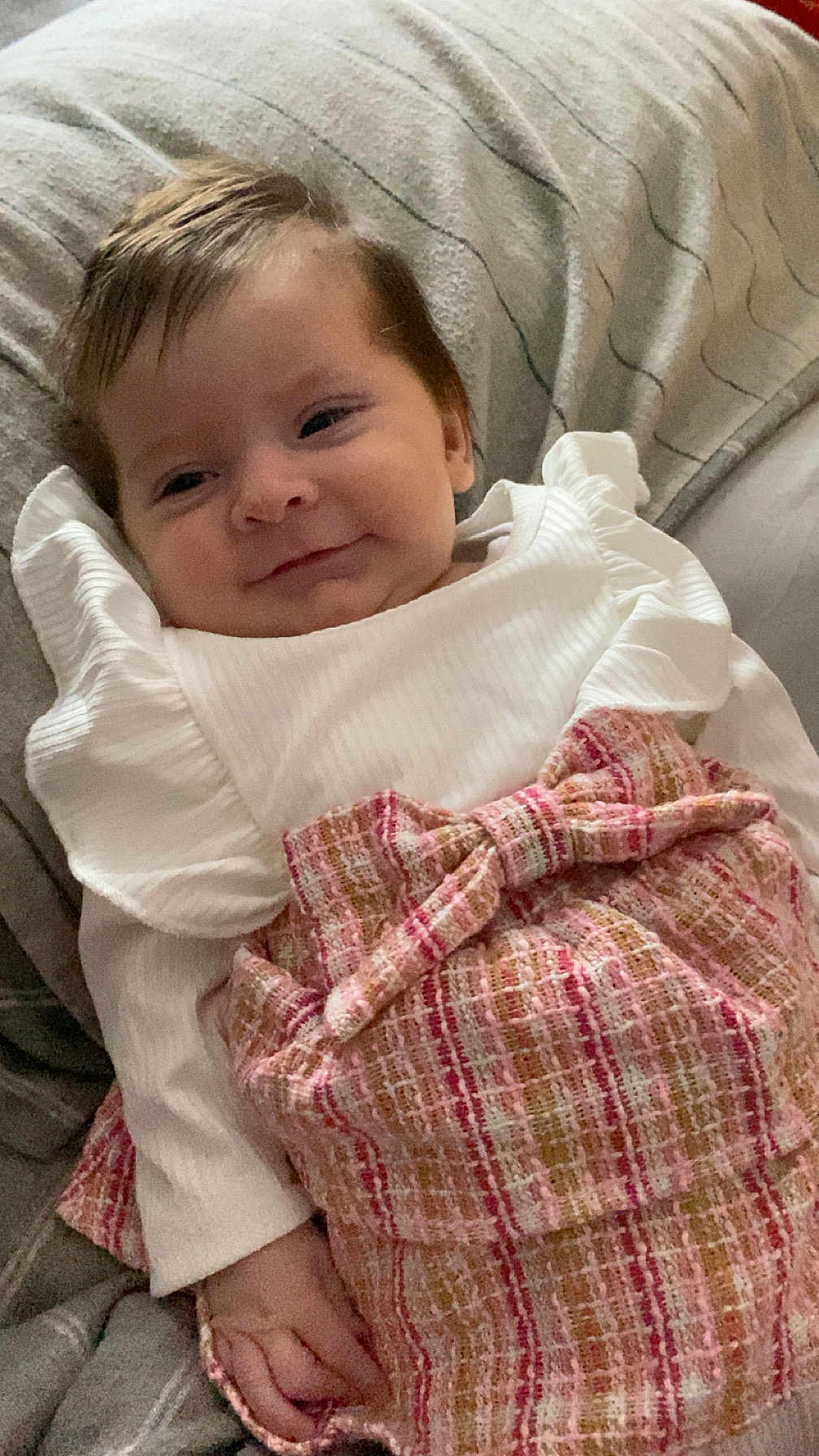 Ayrah joined the competition — help win amazing prizes! baby, infant, smile, white_clothing, pink_skirt, bow, blanket, couch, cozy, child, portrait, cute, happy, person, indoors, soft_lighting, resting, young_child, fashion, ribbons