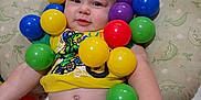 Robert is registered to the contest to win money with this photo: arm, baby, child, colorful_balls, cushion, cute, diaper, face, floor_tiles, happy, indoor, infant, pattern, playtime, portrait, sitting, skin, smiling, toy, yellow_shirt