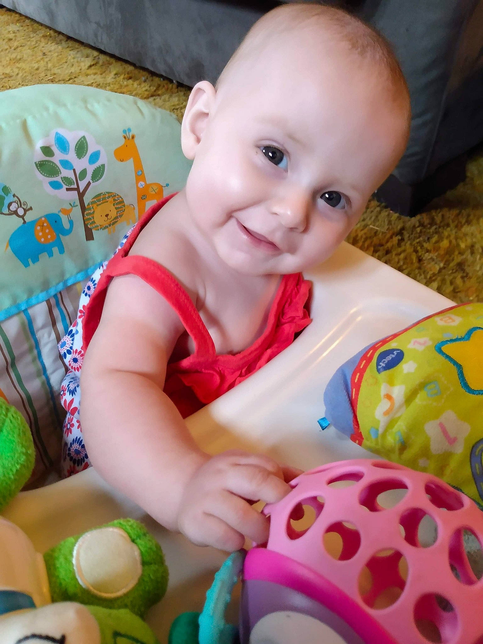 Nova is registered to the contest to win money with this photo: baby, baby_playing_with_toys, baby_products, baby_toddler_clothing, baby_toys, cheek, child, joy, person, pink, play, sitting, skin, smile, toddler, tummy_time