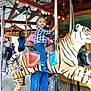Korean Bowers joined the competition — help win amazing prizes! adult, amusement_park, blue_jeans, boots, carousel, child, entertainment, family, fun, happy, indoor, lights, plaid_shirt, pole, ride, smile, support, tiger, toddler, wooden_beams