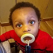 Korean Bowers is registered to the contest to win money with this photo: baby, cabinet, casual, child, closeup, curious, expression, face, home, indoor, infant, looking_up, pacifier, person, portrait, red_shirt, toddler, wooden_floor, young, young_child