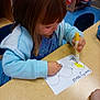 Serenity is registered to the contest to win money with this photo: child, girl, marker, drawing, paper, table, blue_jacket, classroom, chair, hand, coloring, art, kid, preschool, education, wooden_table, activity, young_child, casual_clothing, indoor