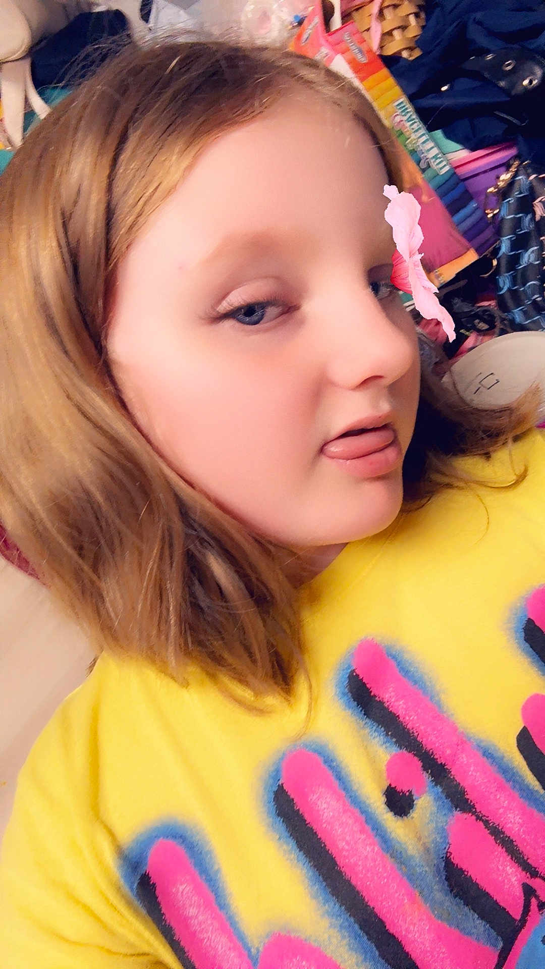 Skylar is registered to the contest to win money with this photo: child, face, yellow_shirt, tongue_out, flower_filter, light_brown_hair, casual, indoor, clothing, colorful, playful, portrait, person, young, fun, expression, filter, messy_background, closeup, smiling