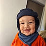baby, child, smiling, hat, scarf, orange_jacket, indoor, face, happy, closeup, person, cute, warm_clothing, portrait, cheerful, infant, headgear, apparel, baby_clothes, young_child