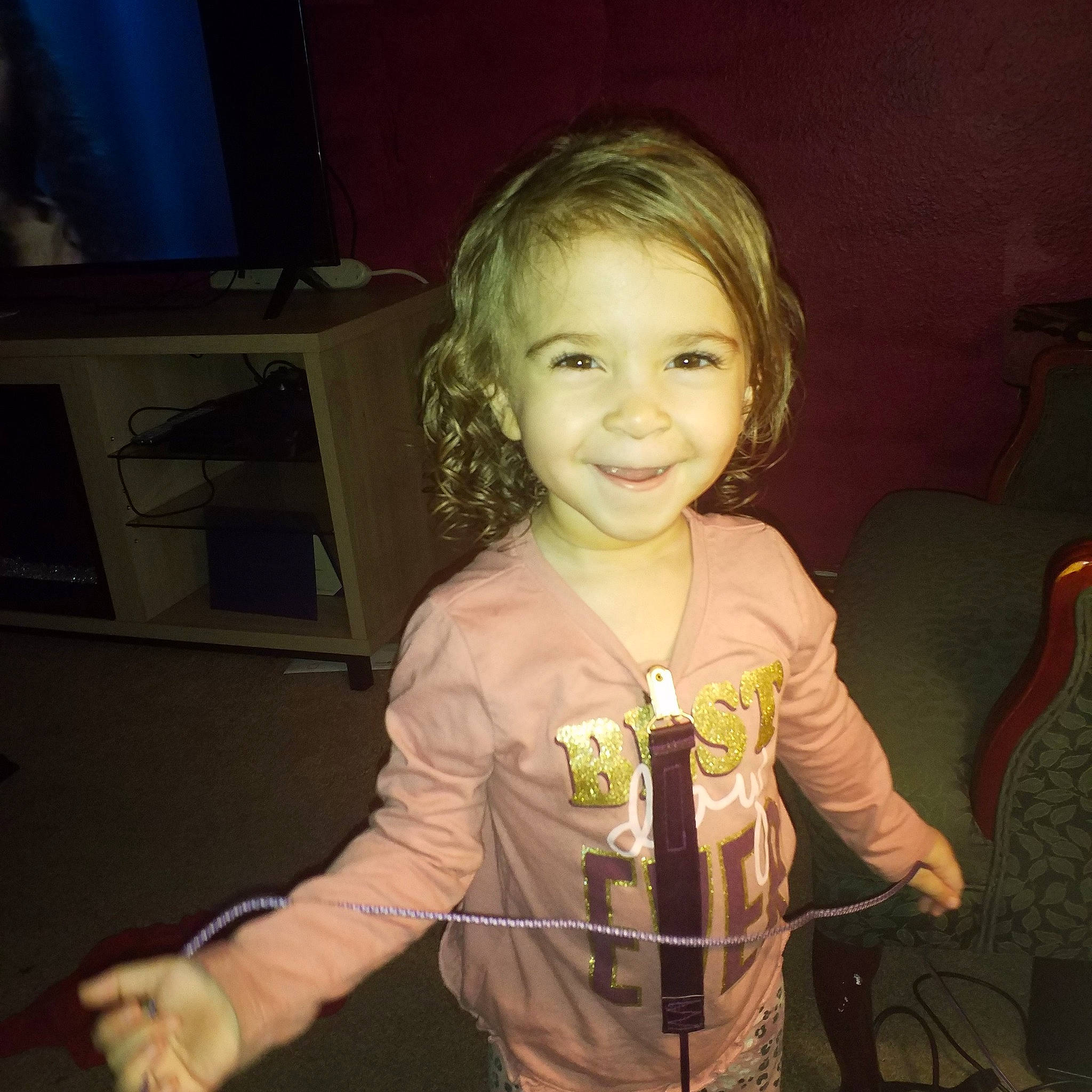 Raina is registered to the contest to win money with this photo: arm, blond, candle, child, curtain, event, eye, fun, hair, happy, head, iris, joy, kitchen_appliance, person, room, smile, t_shirt, television, television_set