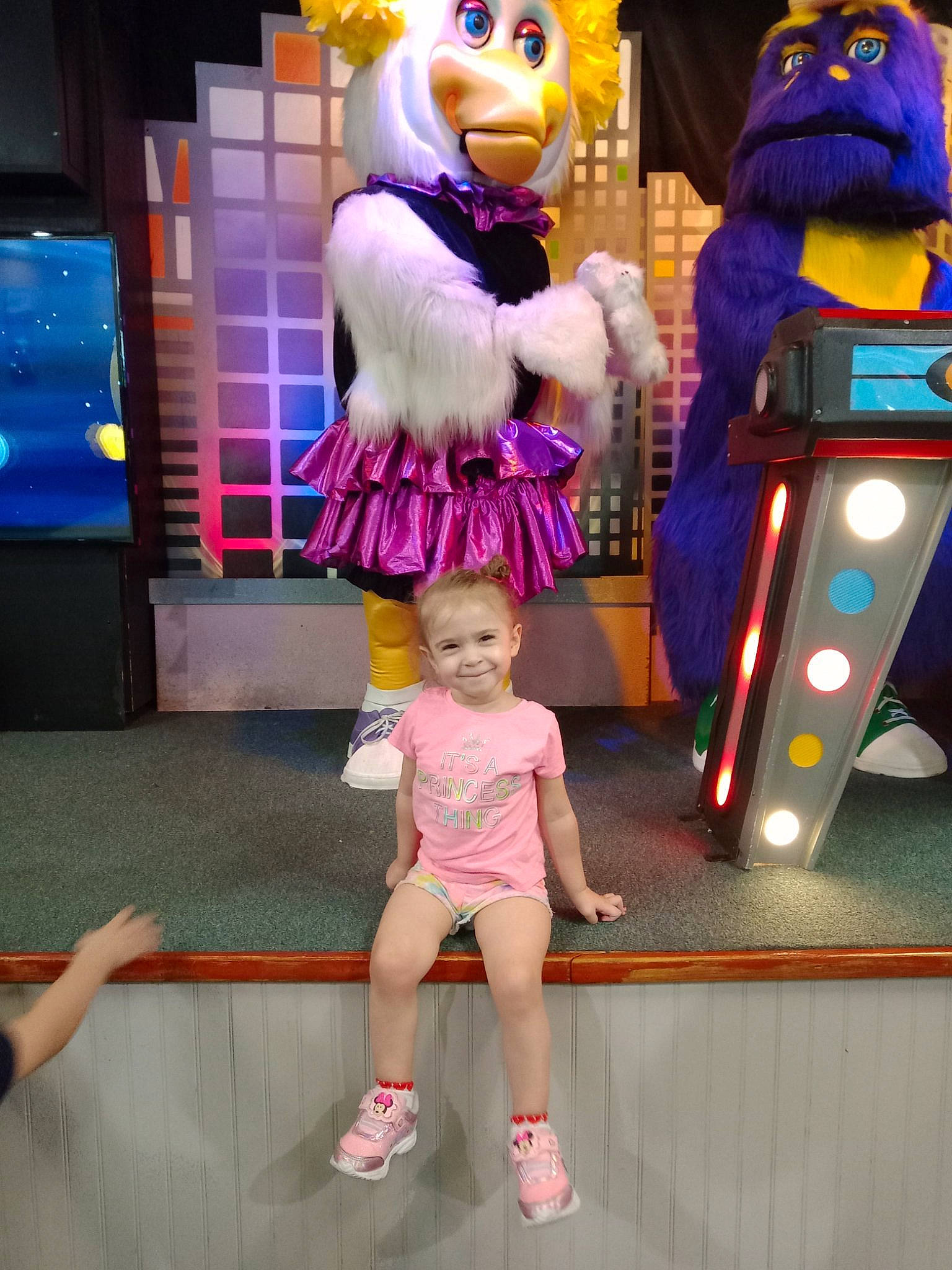 Raina is registered to the contest to win money with this photo: animated_cartoon, blue, clothing, costume, entertainment, event, fun, green, joy, leisure, magenta, mascot, person, photograph, pink, purple, recreation, sandal, shorts, snapshot