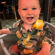 Luca joined the competition — help win amazing prizes! baby, child, smiling, happy, high_chair, shirt, lemon_pattern, indoor, person, face, cute, seated, clothing, infant, portrait, baby_clothes, furniture, hand, eyes, mouth