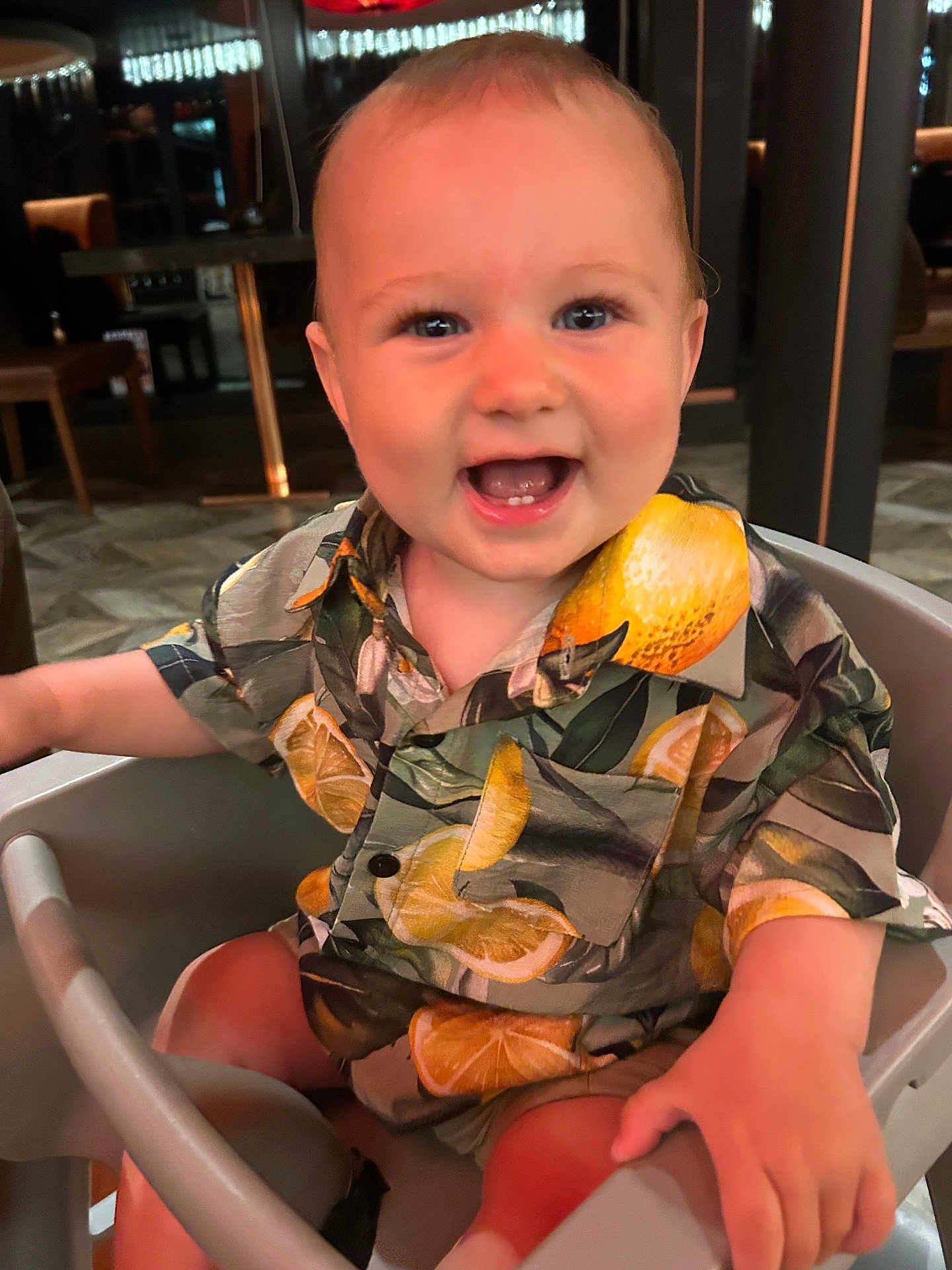Luca joined the competition — help win amazing prizes! baby, child, smiling, happy, high_chair, shirt, lemon_pattern, indoor, person, face, cute, seated, clothing, infant, portrait, baby_clothes, furniture, hand, eyes, mouth