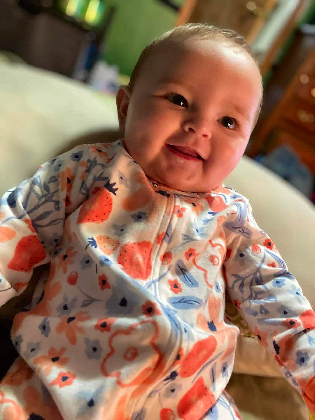 Harper is registered to the contest to win money with this photo: arm, baby, baby_toddler_clothing, cheek, chin, eye, face, facial_expression, happy, head, human_body, iris, joy, mammal, mouth, nose, orange, person, skin, sleeve