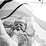 baby, newborn, infant, water, bathtub, hand, support, floating, black_and_white, peaceful, face, skin, person, adult_hand, closeup, quiet, towel, bath, soothing, care