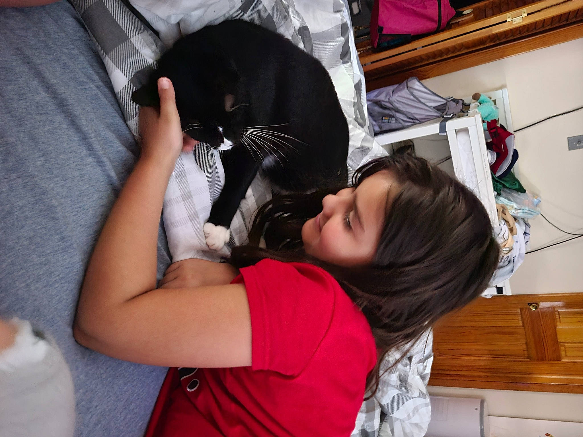 Emma is registered to the contest to win money with this photo: black_hair, cabinetry, chest_of_drawers, child, comfort, drawer, ear, elbow, eyelash, felidae, hair_care, hair_coloring, long_hair, person, room, service, sitting, t_shirt, toddler