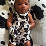 baby, baby_fashion, baby_outfit, black_and_white, blanket, bow, clothing, cow_print, cute, fabric, headband, infant, lying_down, mittens, newborn, pattern, person, portrait, skin, soft