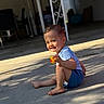toddler, child, rubber_duck, toy, barefoot, shorts, tshirt, outdoor, concrete, sunlight, shadow, smile, happy, sitting, person, young_child, playful, casual, daylight, portrait