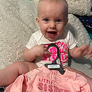 Kinsley joined the competition — help win amazing prizes! apparel, baby, blue_eyes, child, cushion, cute, expression, face, family, hanger, happy, indoor, infant, newborn, onesie, pink_clothing, portrait, sitting, smiling, soft_texture