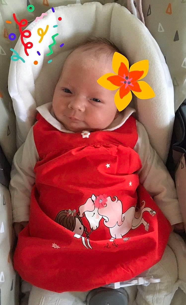 Lilou participe au concours pour gagner de l'argent avec cette photo : baby, baby_products, baby_toddler_clothing, bib, carmine, cheek, child, comfort, flower, happy, lap, linens, pattern, person, petal, red, sitting, skin, sleeve, toddler