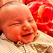 Piper is registered to the contest to win money with this photo: baby, smile, closeup, face, infant, striped_clothing, blanket, soft_light, cute, happy, newborn, warm, cozy, portrait, child, sleepy, young, skin, head, person