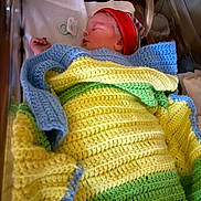 James is registered to the contest to win money with this photo: newborn, baby, sleeping, blanket, crocheted, red_hat, hospital_bassinet, pacifier, infant, child, bed, resting, cozy, cute, portrait, indoors, soft_lighting, peaceful, wrapped, sleep