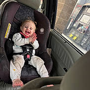 Brylee is registered to the contest to win money with this photo: toddler, child, car_seat, vehicle_interior, gas_station, gas_pump, window, seatbelt, clothing, happy, smiling, hair, pigtails, hands, feet, car, seat, daylight, casual, baby