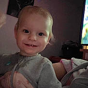 Kai is registered to the contest to win money with this photo: candid, child, cozy, deer, face, gray, happy, home, indoor, jacket, lighting, painting, person, pink, portrait, smiling, television, toddler, wall, young_child