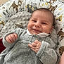baby, smiling, infant, child, gray_outfit, cushion, animal_print, deer, elephant, cozy, patterned, cute, indoor, happy, portrait, small_hand, soft_fabric, lying_down, young, playful